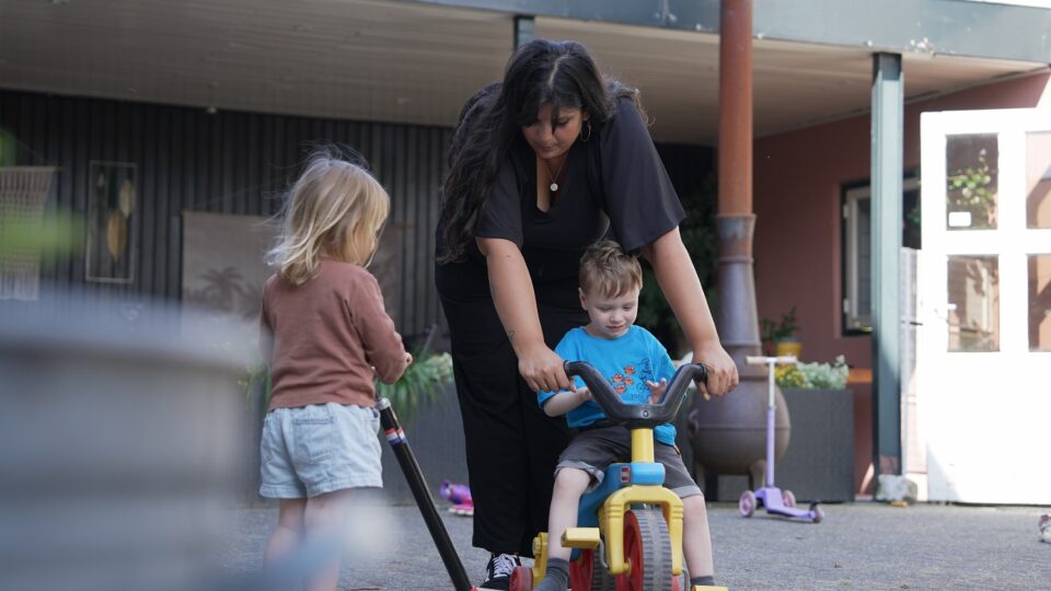 begeleider speelt buiten met twee kinderen